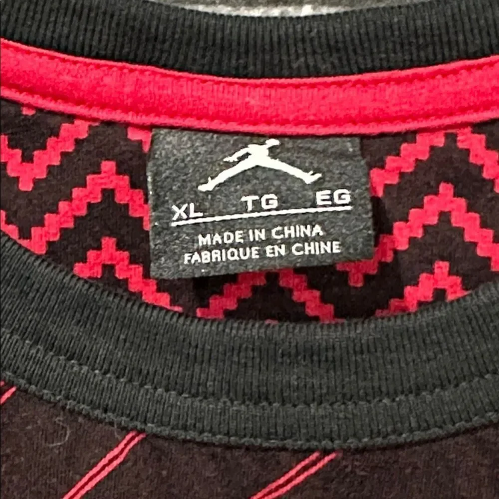 Jordan men's tee in red and black with a unique all-over pattern and a pocket.